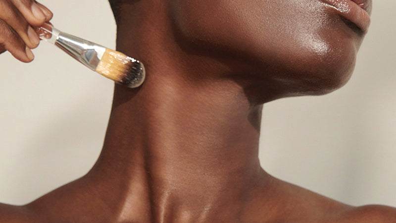 Neck firming treatment being applied to the neck with a brush
